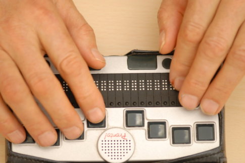 Zwei Hände verwenden ein Braille-Notizgerät zuUmgang mit dem Pronto!-Organizer
